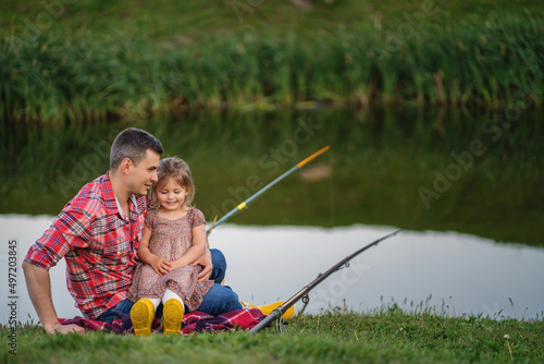 Father with his little daughter fishing near the lake. Joint pastime
