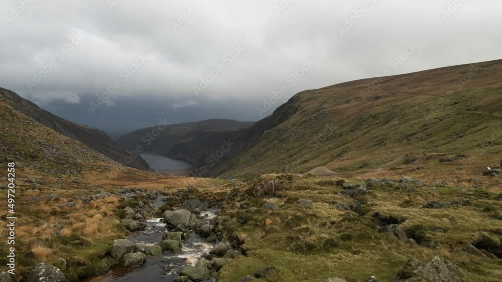 Drone shot of a man hiking through mountains in Ireland. Drone shot of a man hiking through mountains in Ireland.