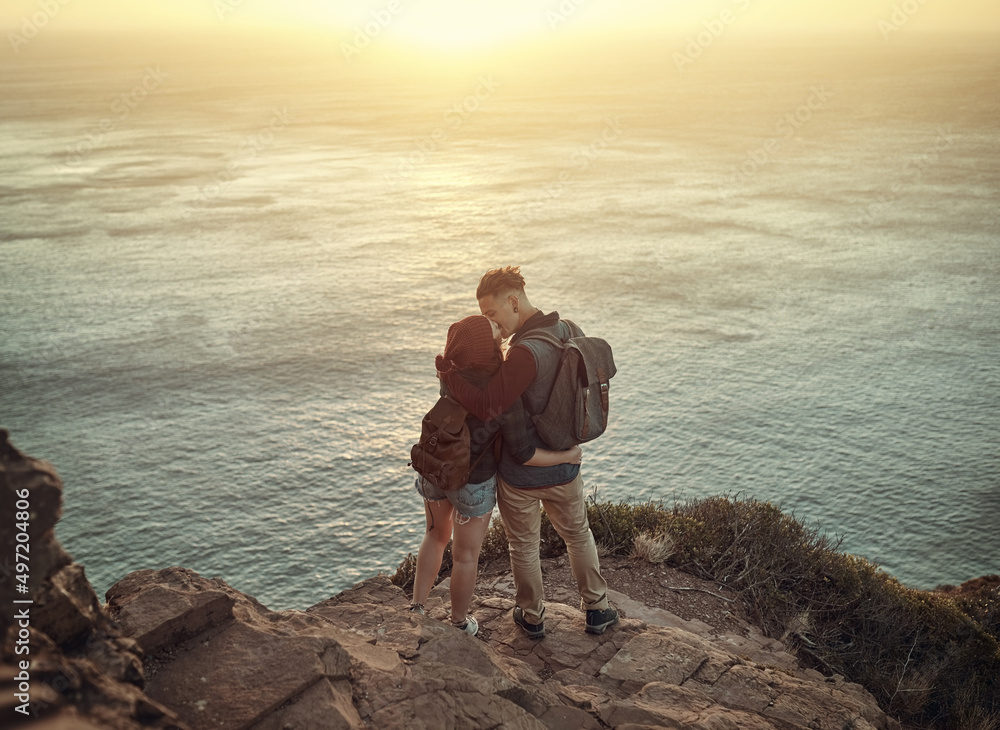 Elevated love. High angle shot of an affectionate young couple kissing on a mountaintop.