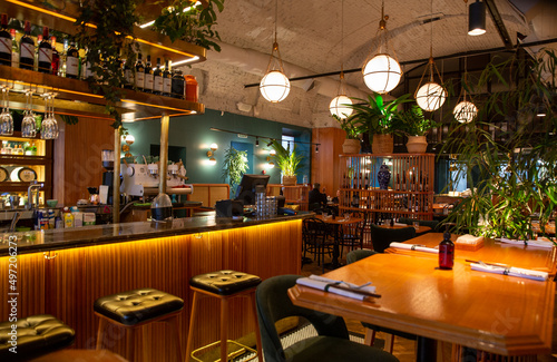 Interior of modern loft style restaurant. Bar counter. Interior porch with fresh flowers