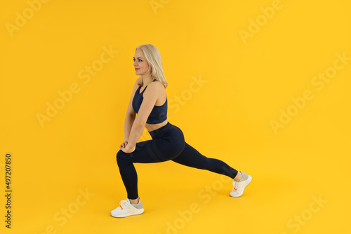 Concept of healthy lifestyle with sporty woman on yellow background