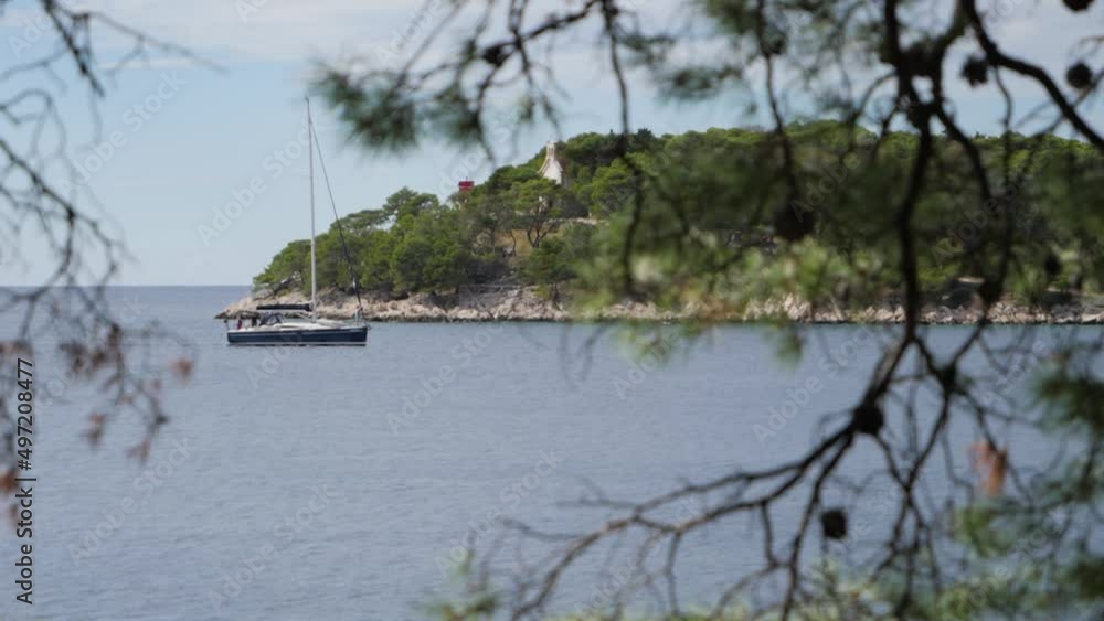 Sailboat pass coast, rack focus from tree, slow motion. Sailboat pass coast, rack focus from tree, slow motion.
