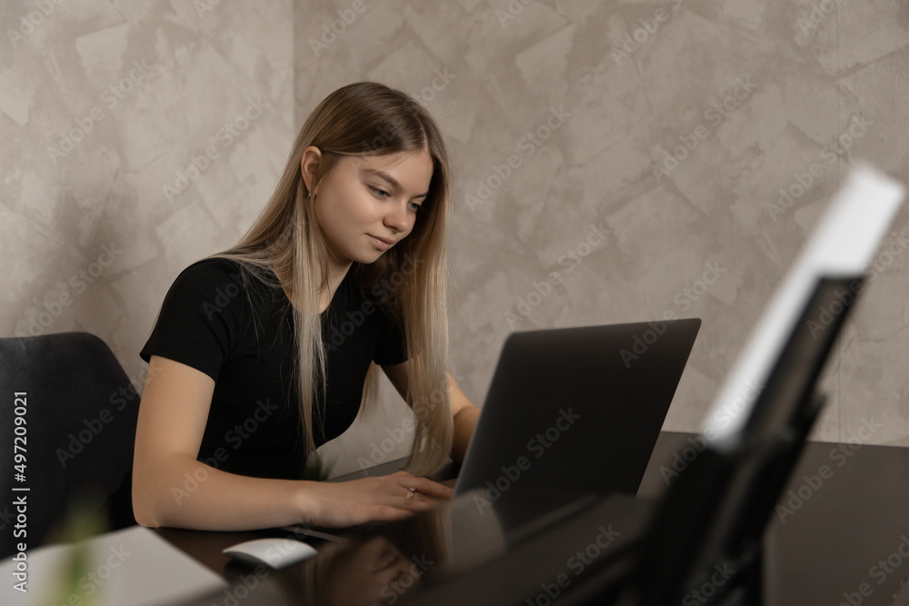beautiful girl works remotely at home at the computer and smiles