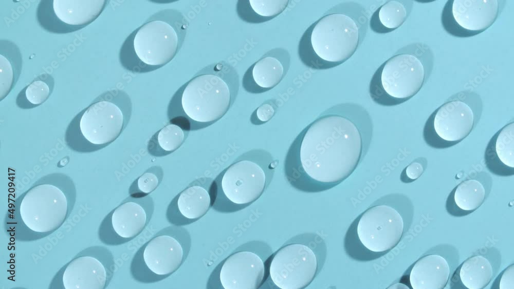 Macro Shot of Cosmetic moisturizing drops of liquid on a green-blue pastel background. Rotation of transparent cosmetic gel fluid, Hyaluronic acid. High quality 4k footage Macro Shot of Cosmetic moisturizing drops of liquid on a green-blue pastel background. Rotation of transparent cosmetic gel fluid, Hyaluronic acid. High quality 4k footage