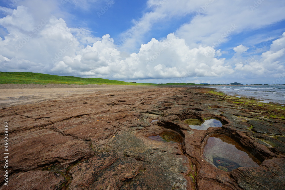 Fototapeta premium rock beach and charming clouds