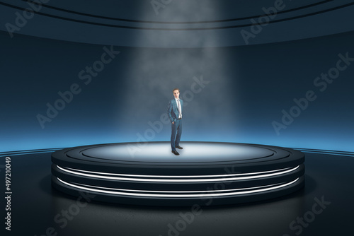 Thoughtful young businessman standing in abstract dark round pedestal interior with spotlight. photo