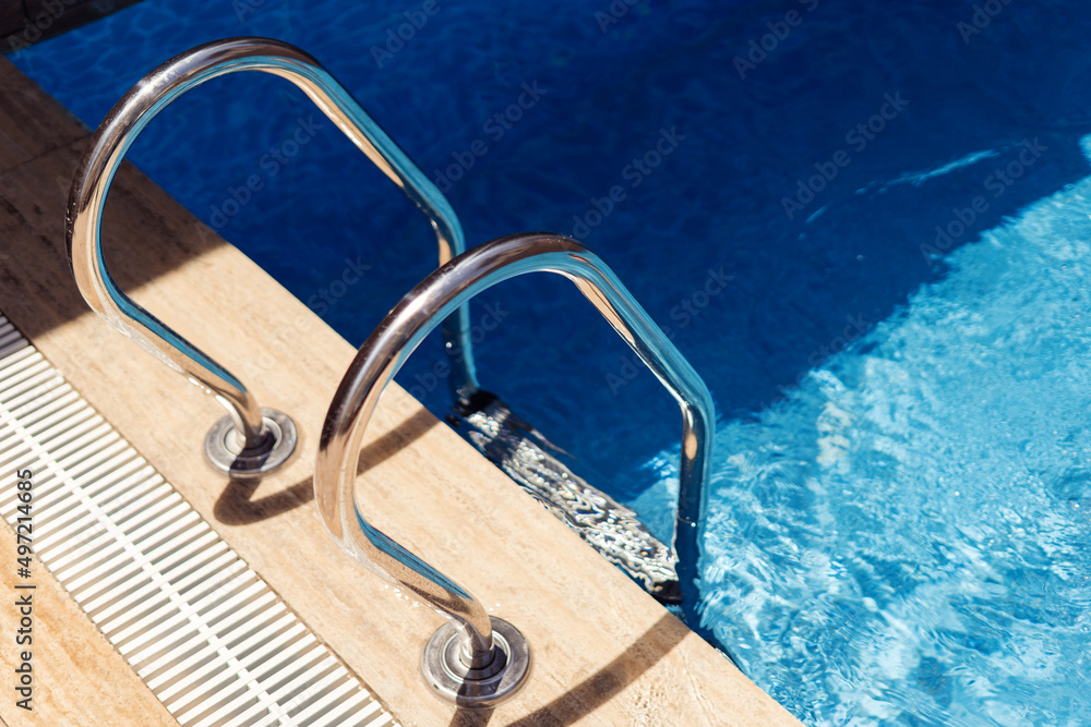 Grab bars ladder in the swimming pool on a sunny day