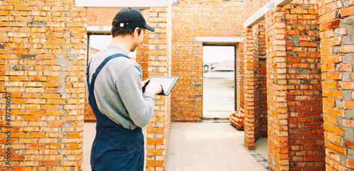 Wallpaper Mural Construction worker standing in the house under construction and holding tablet computer. Torontodigital.ca