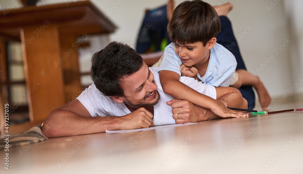 Spending some quality time with his son. Full length shot of a father playing with son on the floor at home. Spending some quality time with his son. Full length shot of a father playing with son on the floor at home.