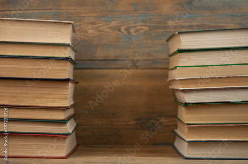 Stack of books on wooden table over rustic background with copy space