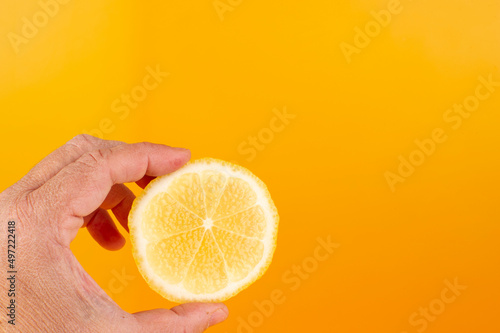 Limones sobre fondo naranja con mano desidratada photo