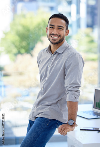 Let no one discourage your ambitions. Portrait of a confident young businessman standing in an office.