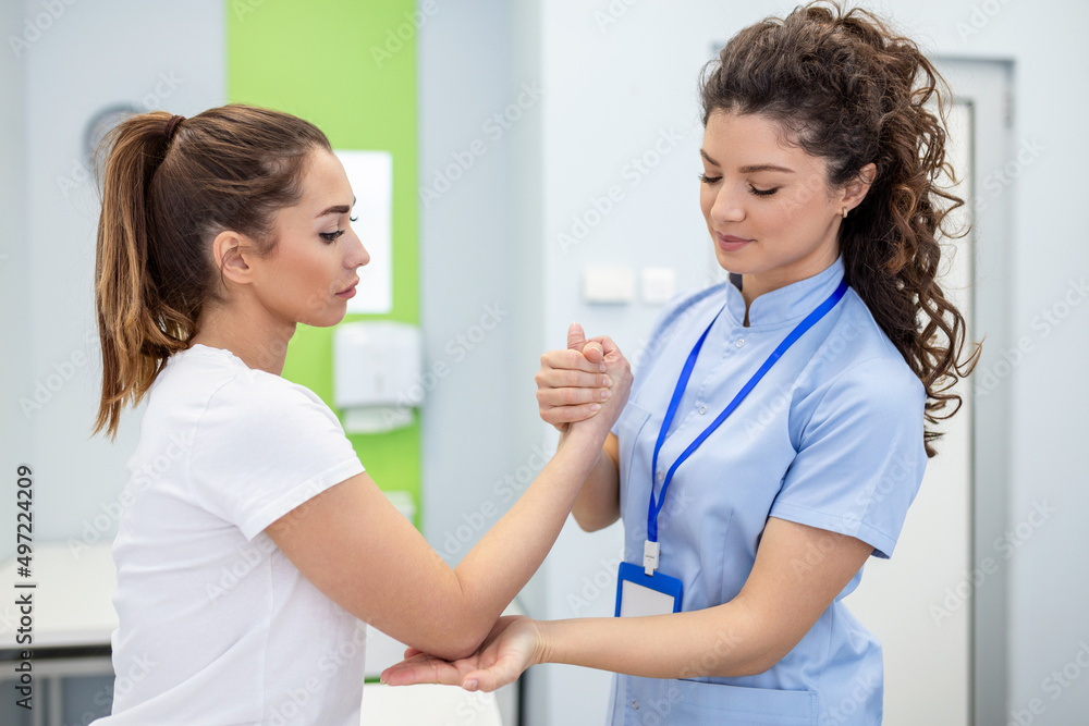 doctor teaching young woman to do osteoporosis treatment exercise in modern clinic. Physiotherapist helping female patient during muscle rehabilitation physiotherapy doctor teaching young woman to do osteoporosis treatment exercise in modern clinic. Physiotherapist helping female patient during muscle rehabilitation physiotherapy