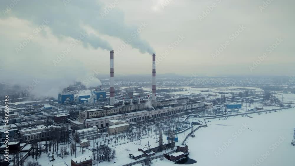 Factory smokestack emissions at cloud winter snow landscape, climate change and global warming for the environment concept.