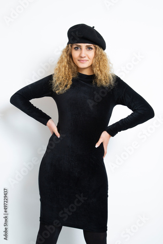 Hünsche junge Frau mit roten Locken, einem schwarzen Kleid und einem schwarzen Béret. Eine junge Künstlein.