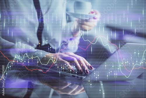 Double exposure of businesswoman hands typing on computer and financial graph hologram drawing. Stock market analysis concept. © peshkova