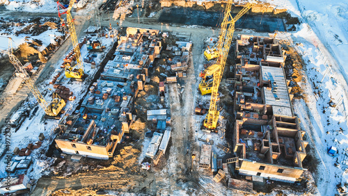 Construction of a residential building. View from above. Snowy winter. Industrial background