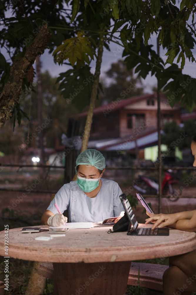 Nurse in protective clothing filling paperwork Nurse in protective clothing filling paperwork