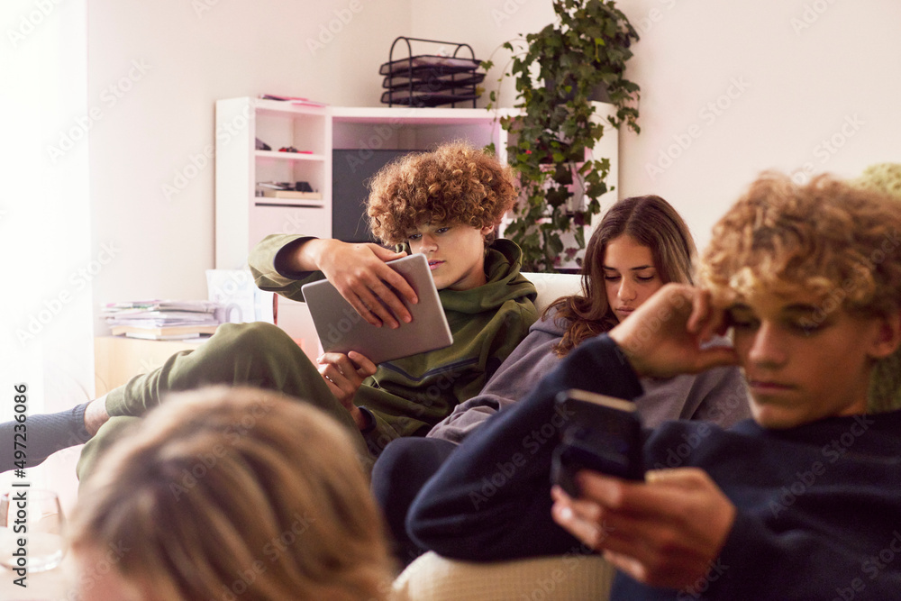 Siblings using electronic devices at home Siblings using electronic devices at home