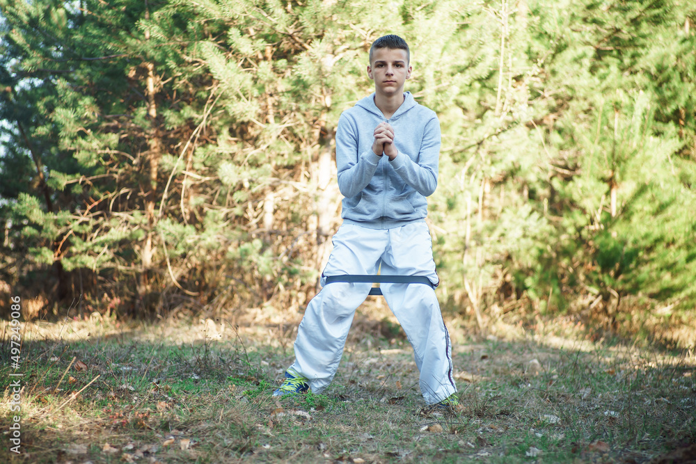 young man trains outdoor in nature, a boy athlete practices a healthy lifestyle