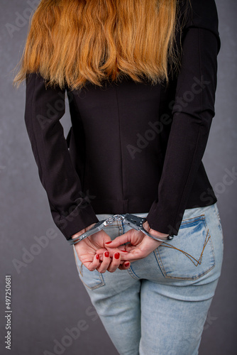 women s hands in handcuffs behind their backs