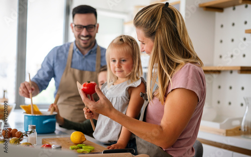 Happy family preparing healthy food together in kitchen. People happiness cooking concept