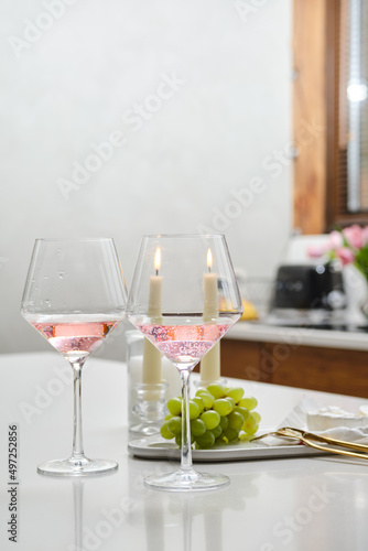 Table with two glasses of rose wine and grape
