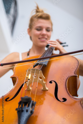 Photo Young woman playing cello on the concert at night
