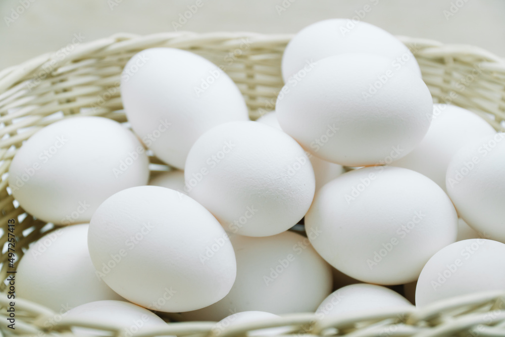 Raw white chicken eggs in a basket top view Raw white chicken eggs in a basket top view