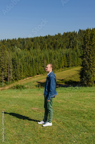 Portrait of a man against the backdrop of the green mountains of the Carpathians