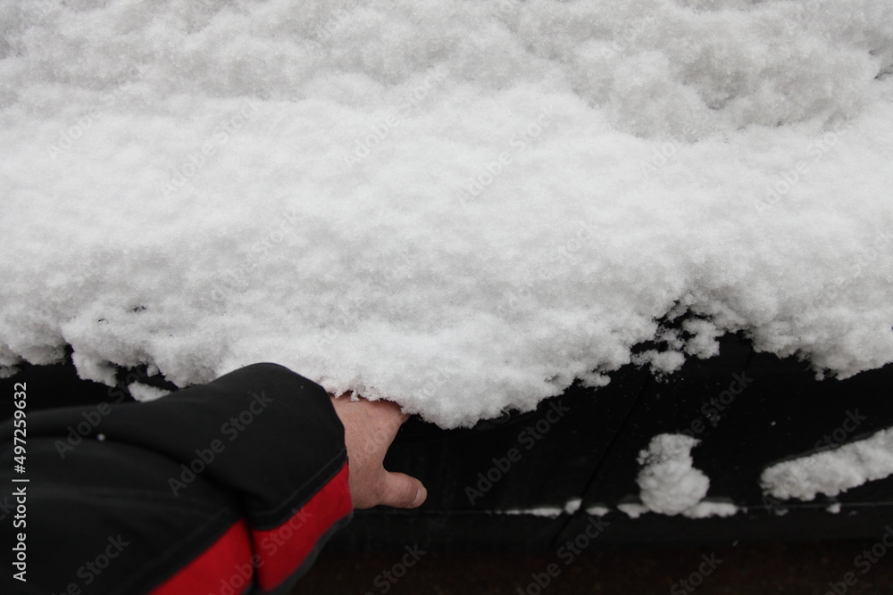 Fototapeta premium Man's hand opens snow covered car door handle from the outside