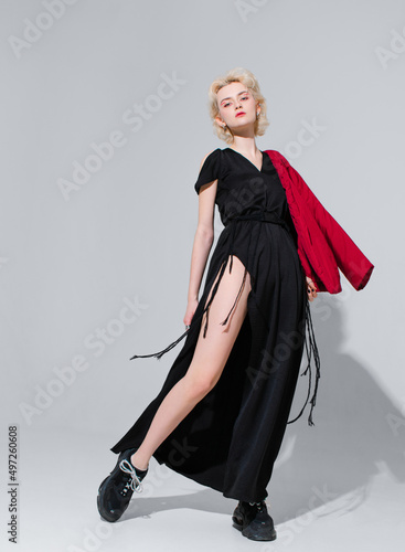 stylish blonde in a black dress with a red jacket