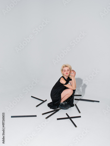 stylish blonde girl in a black fashion dress on a white background