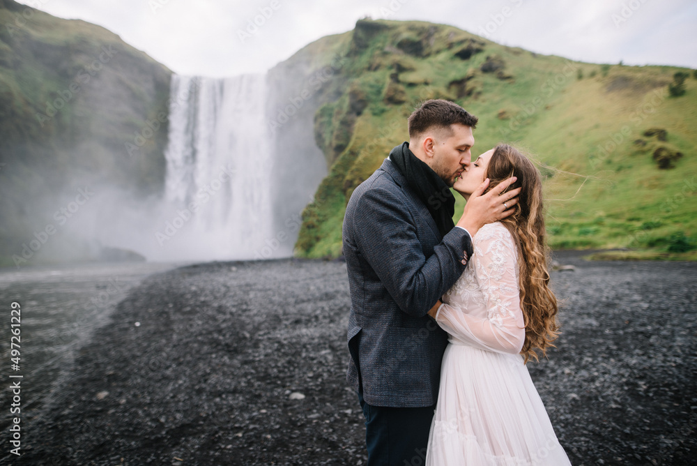 Fototapeta premium Stylish Bride and groom on elopement near Skogafoss waterfall. Iceland wedding 