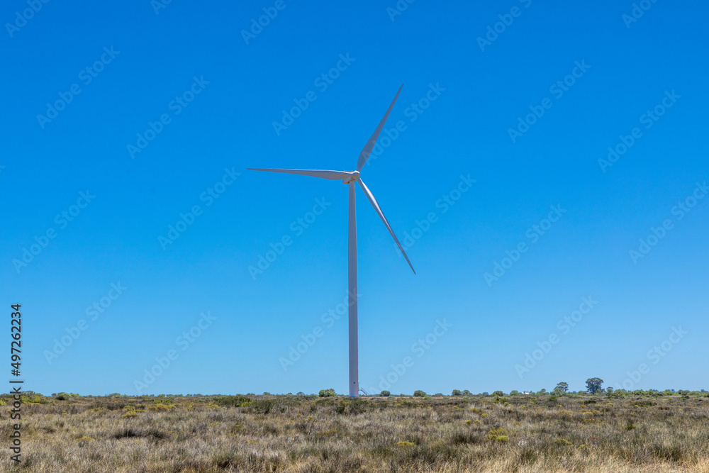 Single wind turbine in a semi arid environment against the clear blue sky. Single wind turbine in a semi arid environment against the clear blue sky.