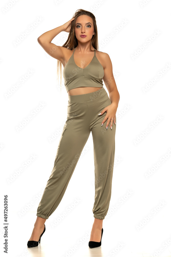 Young woman in trousers standing on a white background Young woman in trousers standing on a white background