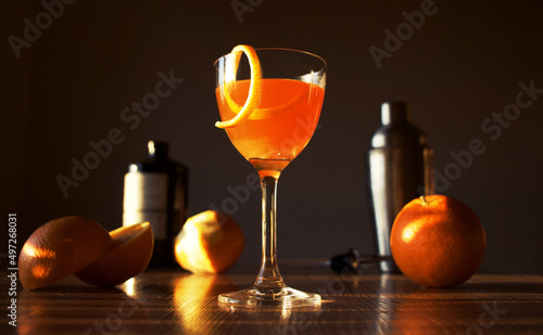 Photo of Nick and Nora orange cocktail with fresh oranges on sunsets background