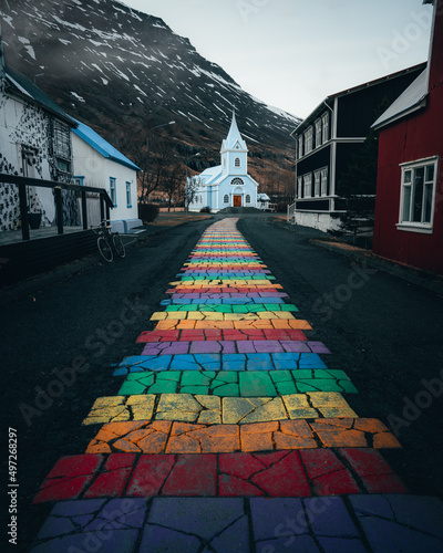Fotografia, Obraz Photo of rainbow boulevard going to white church against of mountain