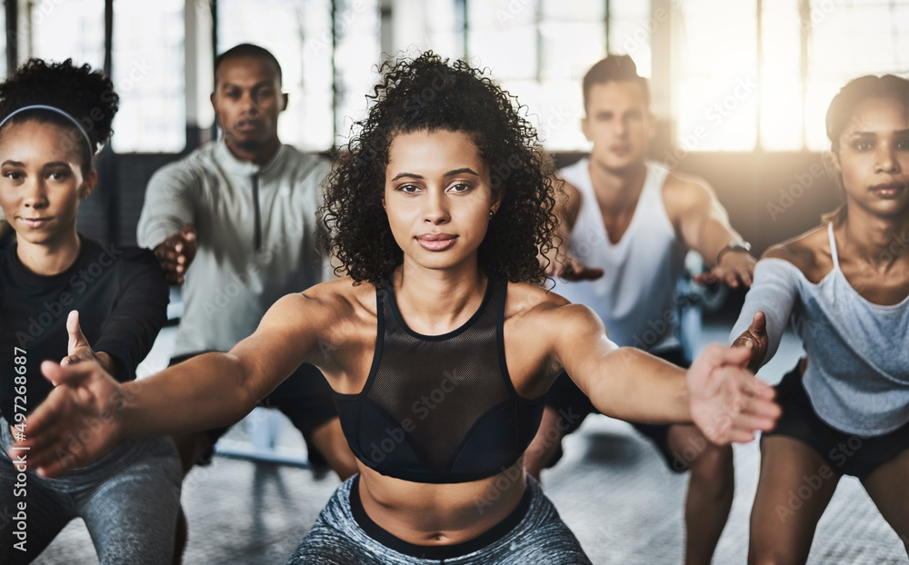 Great things happen when you clear your mind of cant. Shot of a group of young people doing squats together during their workout in a gym. Great things happen when you clear your mind of cant. Shot of a group of young people doing squats together during their workout in a gym.