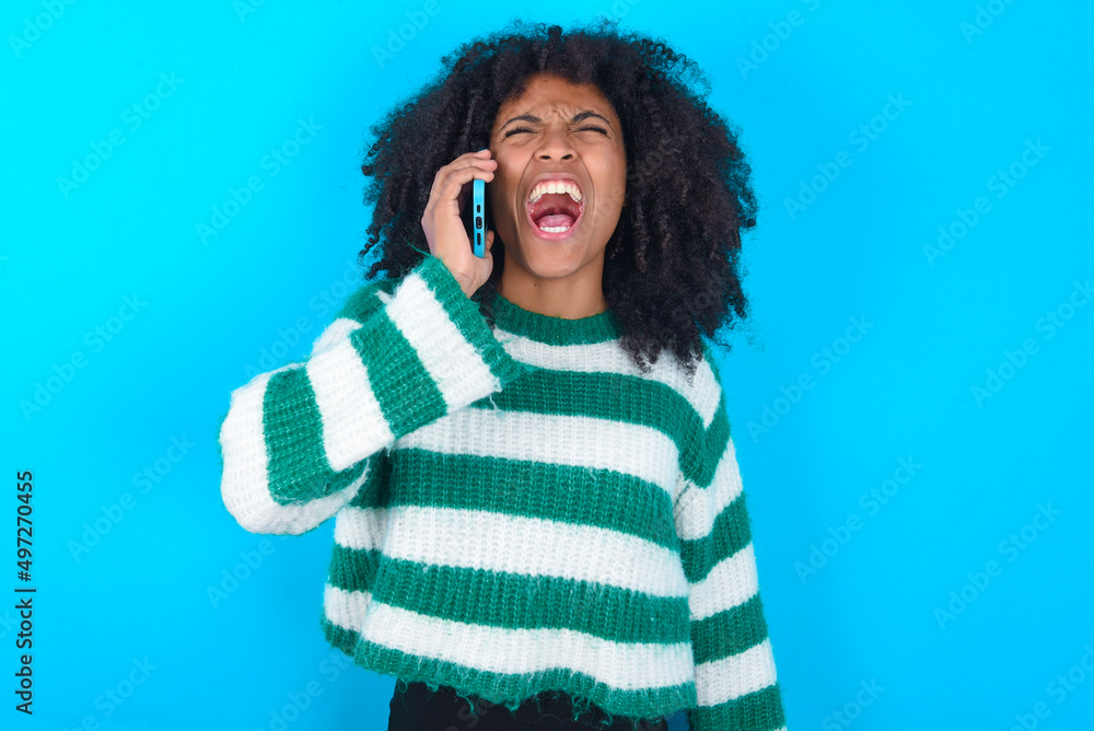 Φωτογραφία Overemotive happy Young woman with afro hairstyle wearing striped sweater over b