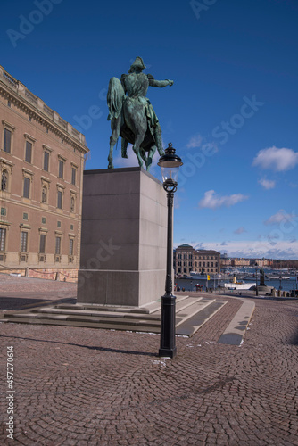 View from the sloop Slottsbacken, king on a horse statue and the bay Strömmen with commuting boats and museums, a sunny spring day in Stockholm