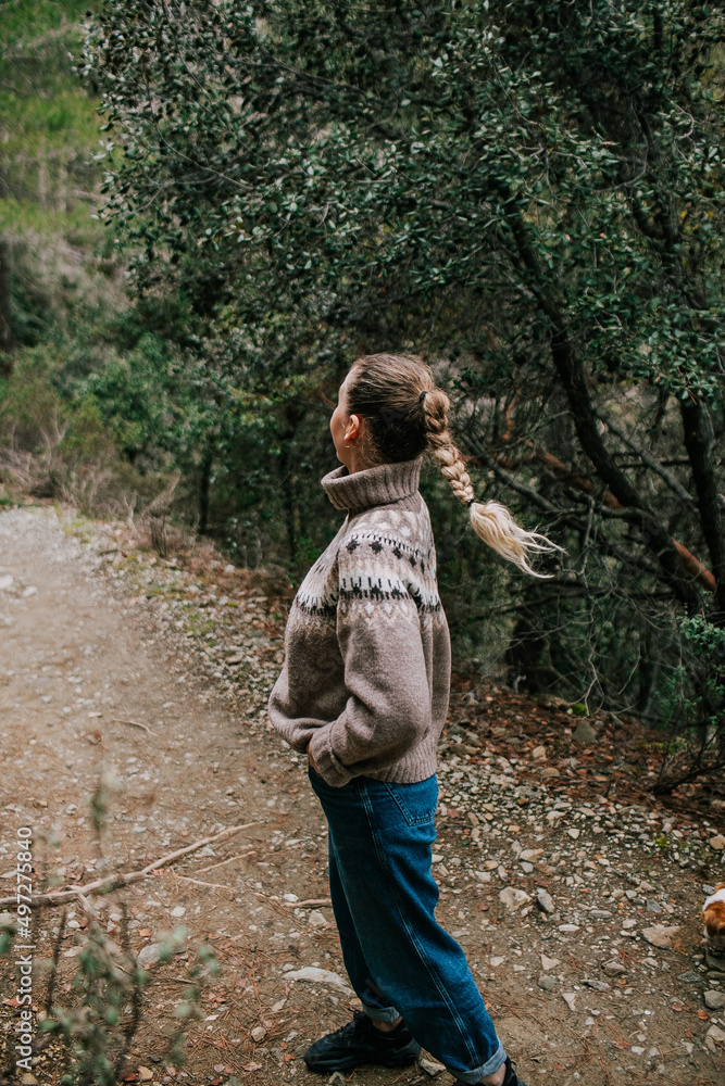 Girl with a pigtail in a sweater from the back, a walk in the forest in nature Girl with a pigtail in a sweater from the back, a walk in the forest in nature