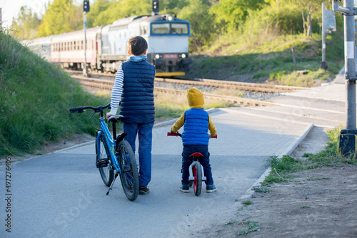 Children, boy brothers, waiting on a railroad cross to pass a train