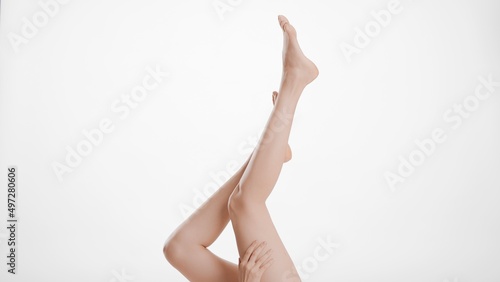 Medium shot of flawless female legs on white background   Unwanted hair removal and leg care concept