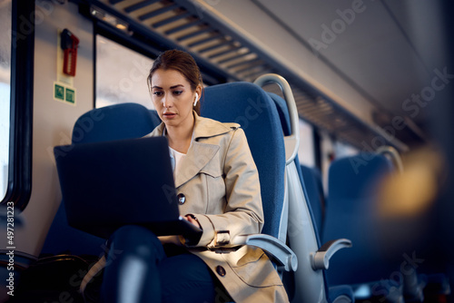 Canvastavla Young businesswoman works on laptop while commuting to work by train