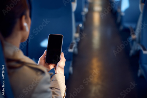 Close up of woman uses mobile phone while commuting by train. photo