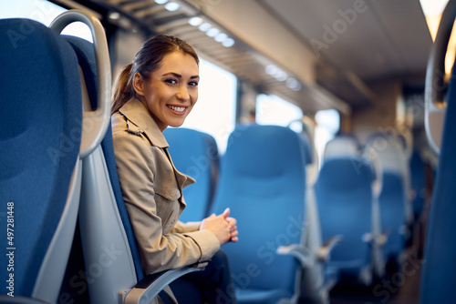 Young happy woman traveling by train and looking at camera. photo