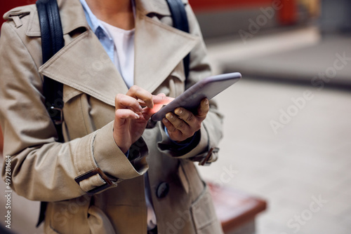 Close up of passenger using smart phone at train station.