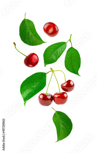 Flying fresh sweet cherry with green leaves on a white background.