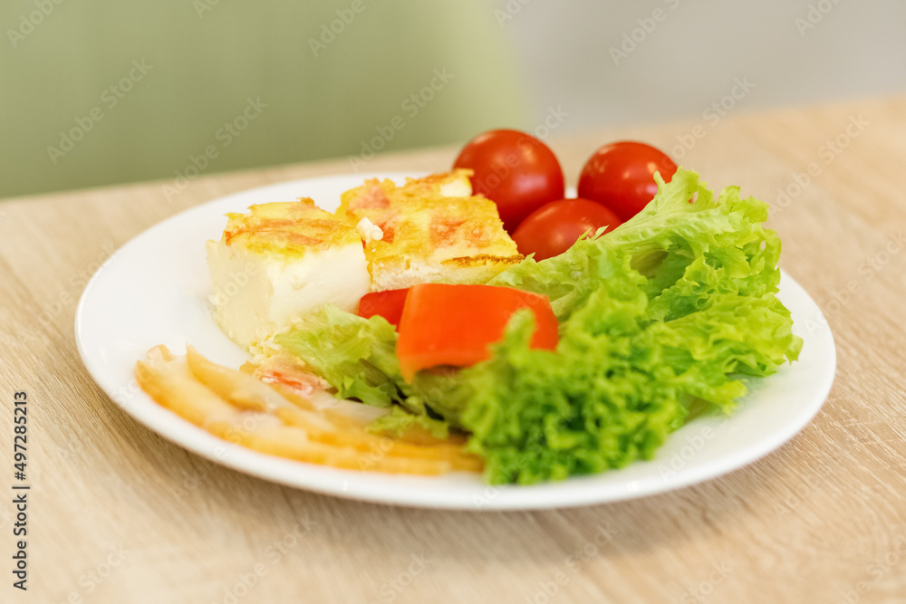 Lettuce leaves, tomatoes, omelet. Fresh vegetables on a plate. Proper nutrition, a healthy need for life. Lettuce leaves, tomatoes, omelet. Fresh vegetables on a plate. Proper nutrition, a healthy need for life.